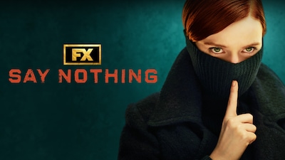 Woman with red hair and green eyes wearing a black turtleneck over her face and shushing.